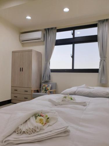 a bedroom with a white bed with flowers on it at 金門民宿 x 花藝雅築 The Flower Hut in Jinhu