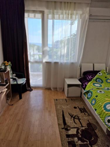 1 dormitorio con cama y ventana grande en Апартамент широк център варна15 минути до центъра, en Varna
