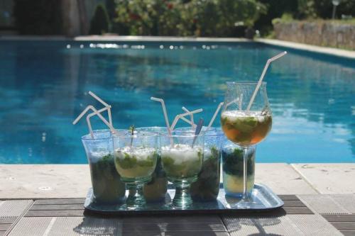 - un plateau avec 3 boissons sur une table à côté de la piscine dans l'établissement Suite de l'olivier au Mas au Coeur de la Provence &SPA, à Saint-Cannat