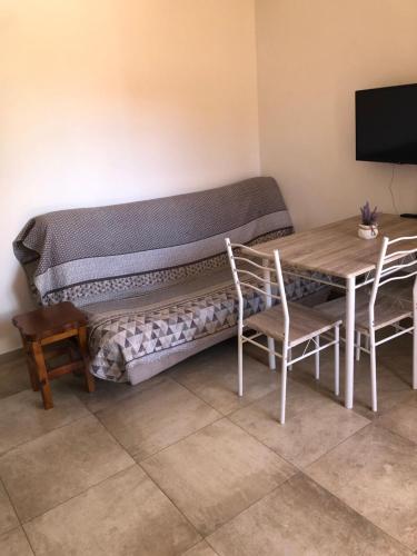 um banco num quarto com uma mesa e uma televisão em Apartments Tonka em Zadar