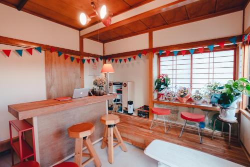 SLOW HOUSE kesennuma - Vacation STAY 30922v في Kesennuma: بار في غرفة مع كراسي حمراء ومكتب