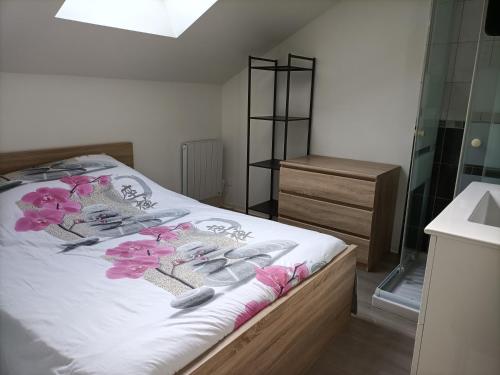 a bedroom with a bed with pink flowers on it at F1 en duplex coquelicot in Lamalou-les-Bains