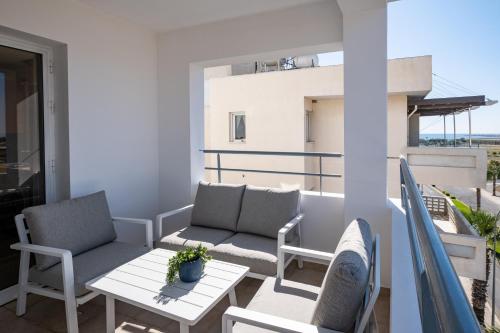 a balcony with a table and chairs on a balcony at The Saline Views Makenzy in Larnaka