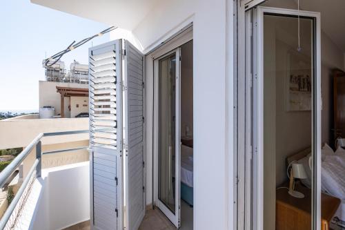 a room with a balcony with a window and a ladder at The Saline Views Makenzy in Larnaka