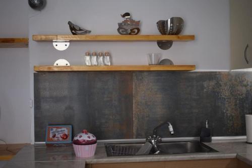 a kitchen with a sink and a cupcake on a counter at h2h Levandre Άνετο διαμέρισμα στην Καλλιθέα in Athens