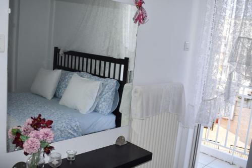 a bedroom with a mirror of a bed with flowers on a table at h2h Levandre Άνετο διαμέρισμα στην Καλλιθέα in Athens