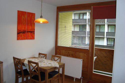 a dining room with a table and chairs and a window at Appartement Schwarzenbacher in Kaprun