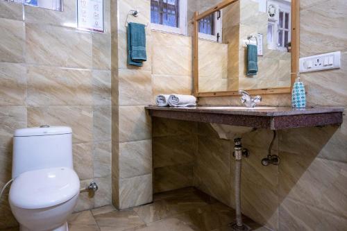 a bathroom with a toilet and a sink at StayVista at Misty Mountains Cottage in Kasauli
