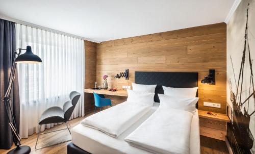 a bedroom with a white bed and a desk at Best Western Hotel Das Donners in Cuxhaven
