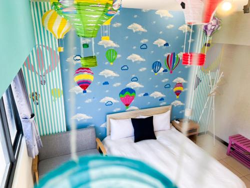um quarto com uma cama com balões e nuvens em 一中小窩馨 em Taichung