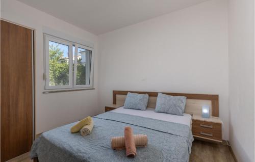 a bedroom with a bed with two stuffed animals on it at Stunning Apartment In Njivice With Wifi in Njivice