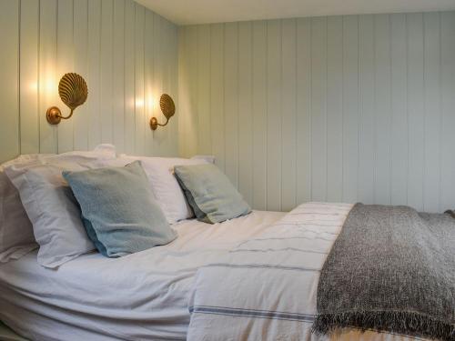 a large white bed with pillows in a room at Shepherds Beachhouse in Pagham