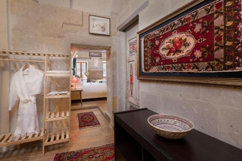 a room with a wall with a rug and a table at HacıAşık Konağı Butik Hotel in Avanos