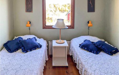 Habitación con 2 camas, almohadas azules y lámpara. en Awesome Home In Oskarshamn With 1 Bedrooms And Wifi en Oskarshamn