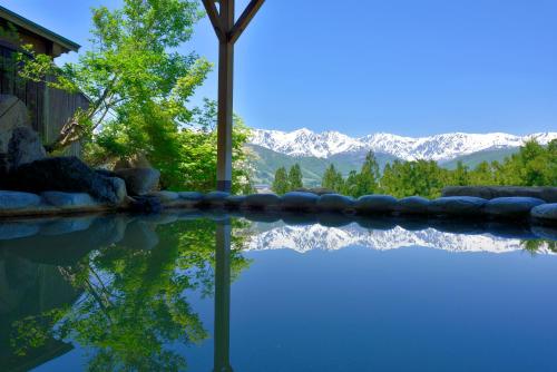a swimming pool with a view of the mountains at Hakuba Highland Hotel in Hakuba