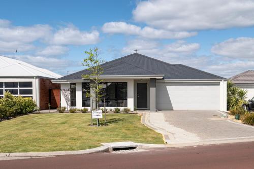 a house with a sign in the front yard at Cabot's Creche in Dunsborough