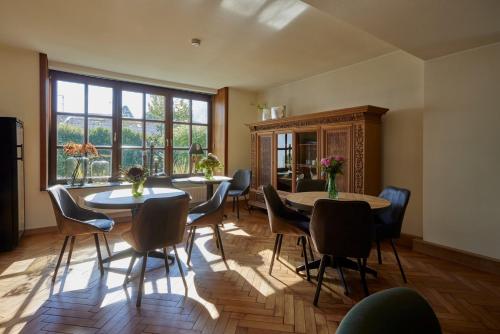 a dining room with two tables and chairs and a window at Erler Koornhuus in Raesfeld