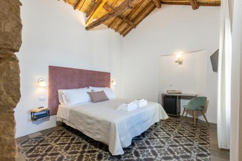 Habitación de hotel con cama y escritorio en Monte Forru, en Baunei