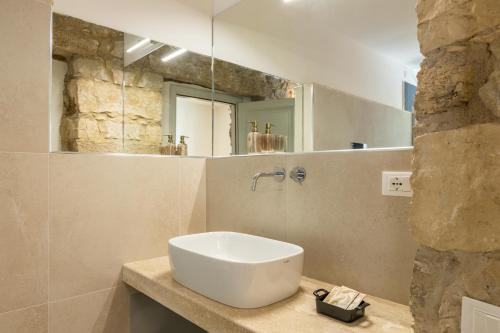 a bathroom with a white sink and a mirror at Monte Forru in Baunei