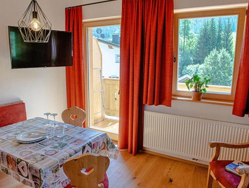 a dining room with a table and a large window at Rodahof in Sesto
