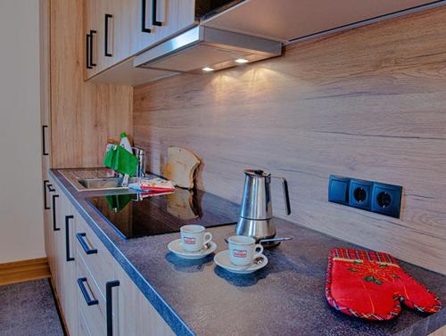 a kitchen counter with two cups and a kettle on it at Rodahof in Sesto