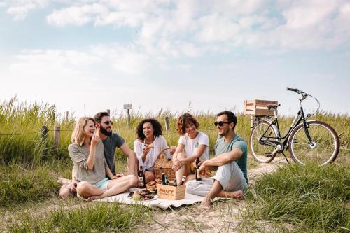 a group of people sitting around a picnic blanket at Best Western Hotel Das Donners in Cuxhaven