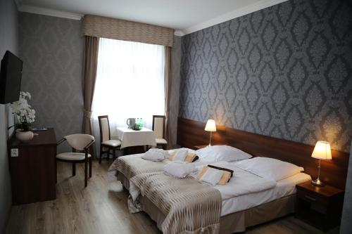 ポルチンズドロイにあるUzdrowisko Polczyn Gryfのベッド2台と窓が備わるホテルルームです。