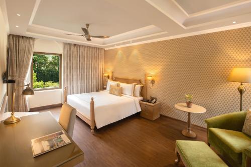 a hotel room with a bed and a couch at Heritage Village Resort & Spa Manesar-Gurgaon in Gurgaon