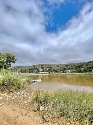 a body of water with trees and hills in the background at Living The Breede - Inhoek Farm Farmhouse in Malgas