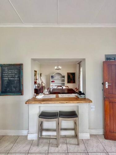 a kitchen with two stools at a counter in a room at Living The Breede - Inhoek Farm Farmhouse in Malgas
