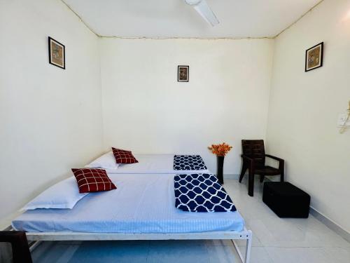a bedroom with two beds and a chair at Hostel ivory in Jaipur