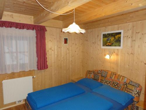 ゼルデンにあるAppartement Agostiniの木製の壁のベッドルームで、青いベッド1台が備わります。