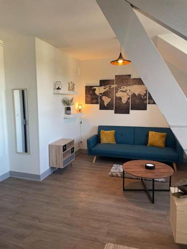 un salon avec un canapé bleu et une table dans l'établissement T2 4 pers face gare SNCF Appart Hotel le Cygne 6, à Bourges