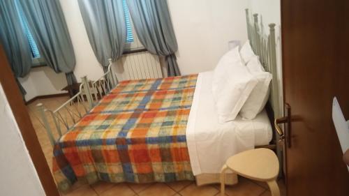 a bedroom with a bed with a colorful blanket at le lanterne in Foligno