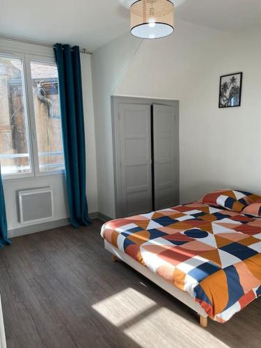 une chambre avec un lit et une fenêtre avec des rideaux bleus dans l'établissement T2 4 pers face gare SNCF Appart Hotel le Cygne 6, à Bourges