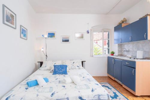 um quarto com uma cama e uma cozinha com armários azuis em Apartman studio Stari Grad 2 em Stari Grad