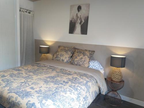 a bedroom with a bed with two lamps on it at Gabrielle 40m2 et terrasse in Sainte-Savine