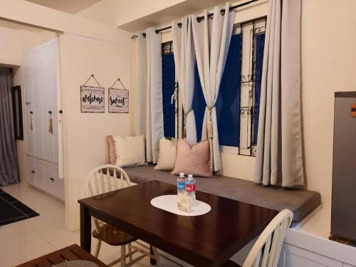 uma sala de jantar com uma mesa com duas garrafas em 1 BR Cozy Farmhouse-Style Condo with Balcony & Taal View at Wind Residences em Tagaytay