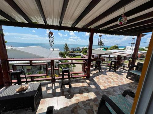 a patio with tables and chairs and a view of the ocean at Posada Ashanty in Providencia