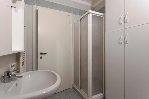 ein weißes Bad mit einem Waschbecken und einer Dusche in der Unterkunft QUIET PLACE close to city center in Desenzano del Garda