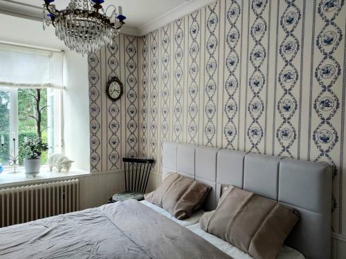 - une chambre avec un lit et un lustre dans l'établissement Hoby Gård B&B, à Bräkne-Hoby