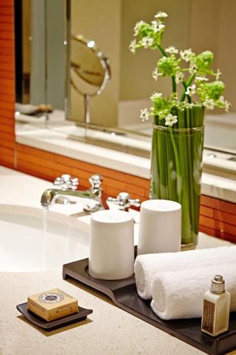 a bathroom with a sink with towels and a mirror at Eslite Hotel in Taipei