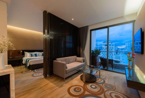 a hotel room with a bedroom and a bed and a couch at Queen Ann Nha Trang Hotel in Nha Trang