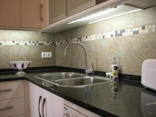 a kitchen with a sink and a counter top at Almargem Villa 77 Cozy 1BR in Cabanas de Tavira, Near the Beach in Cabanas de Tavira