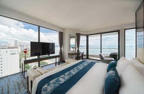 a bedroom with a large bed and a large window at Queen Ann Nha Trang Hotel in Nha Trang