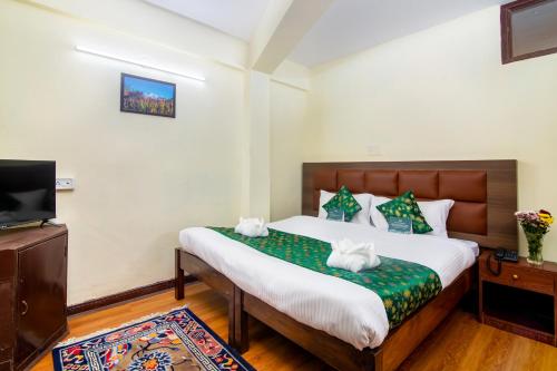 a hotel room with a bed and a tv at Muscatel BhumSang - 200 Mts from Mall Road in Darjeeling
