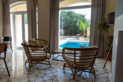 a living room with chairs and a swimming pool at The Carob Tree in Victoria