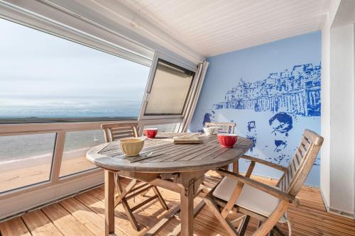 une table et des chaises dans une pièce avec vue sur l'océan dans l'établissement Face à la mer, appartement sous les toits pour 4, à Pornichet