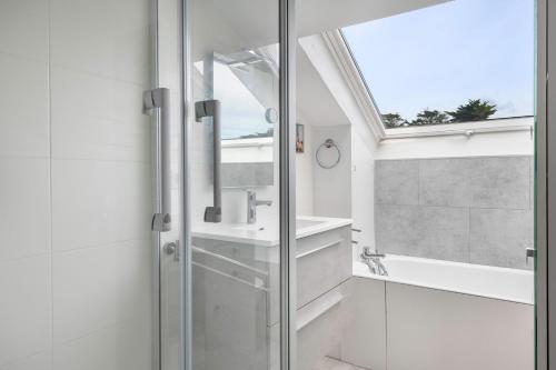 a bathroom with a shower and a sink and a window at Face à la mer, appartement sous les toits pour 4 in Saint-Sébastien