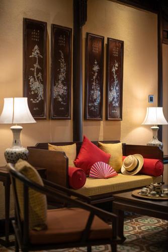 a living room with a couch with colorful pillows at Ancient Huế Garden Houses in Hue